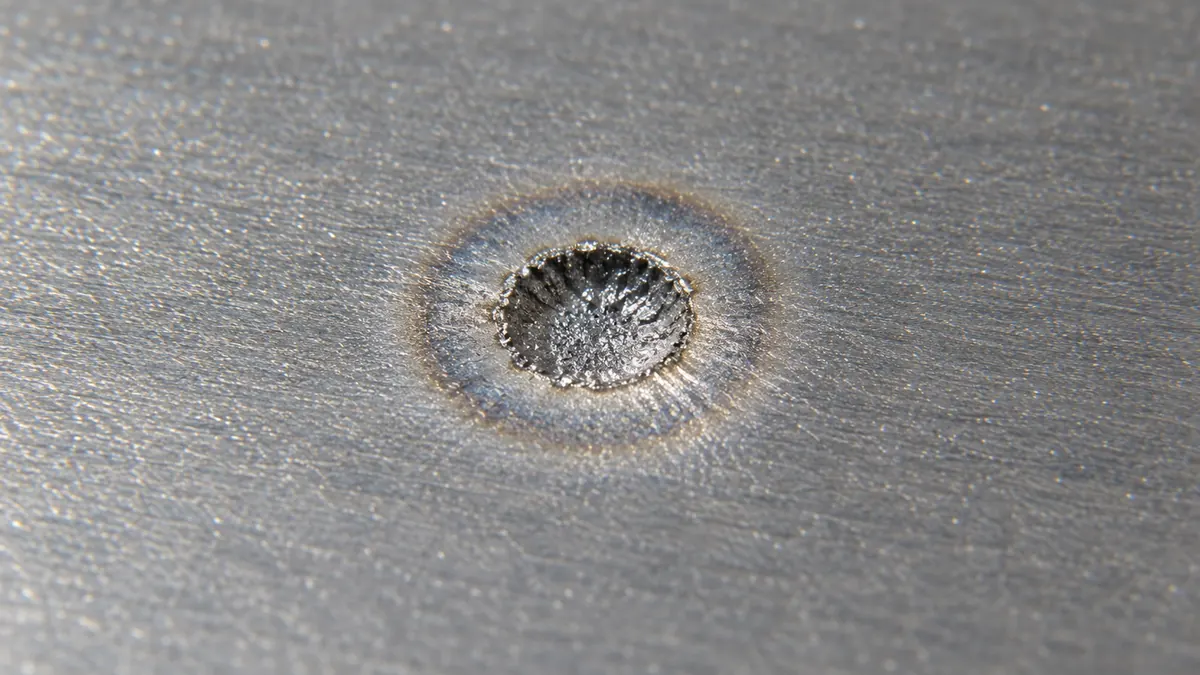 Microscope view of a central laser ablation zone surrounded by a faint threshold boundary